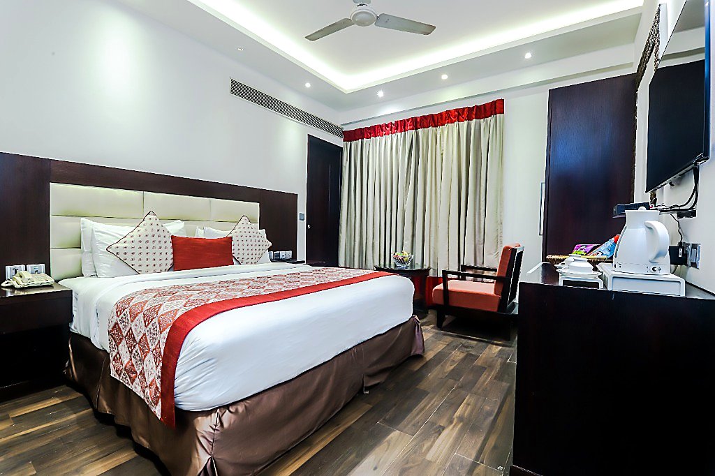Superior Room at Hotel Grand Godwin New Delhi — boutique double bed with traditional Indian runner, tea station, and centralized room warmer