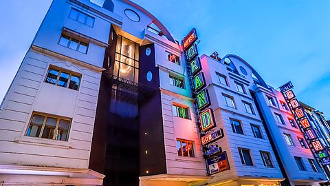 Hotel Grand Godwin exterior facade illuminated at dusk with neon sign and Cafe Brownie in Paharganj New Delhi